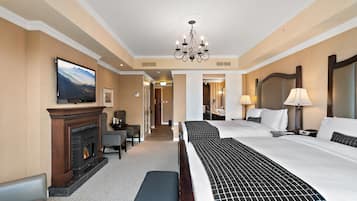 Una habitación de hotel con chimenea, una cama grande, un candelabro y un televisor.