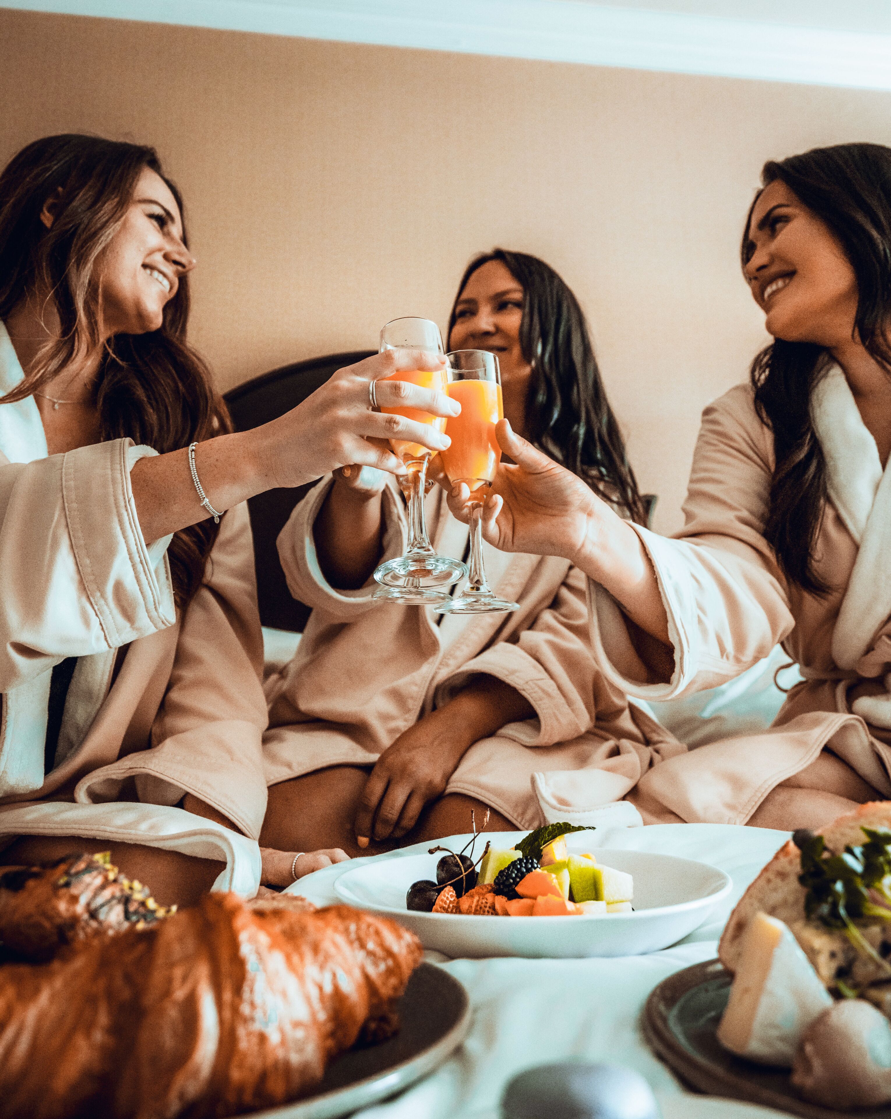A group of people in matching robes sitting around a table with a meal and drinks.