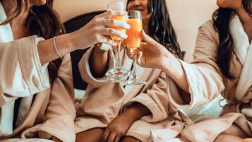 A group of people in matching robes sitting around a table with a meal and drinks.