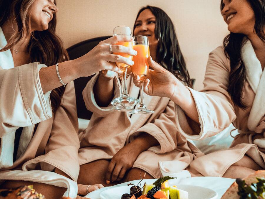 A group of people in matching robes sitting around a table with a meal and drinks.