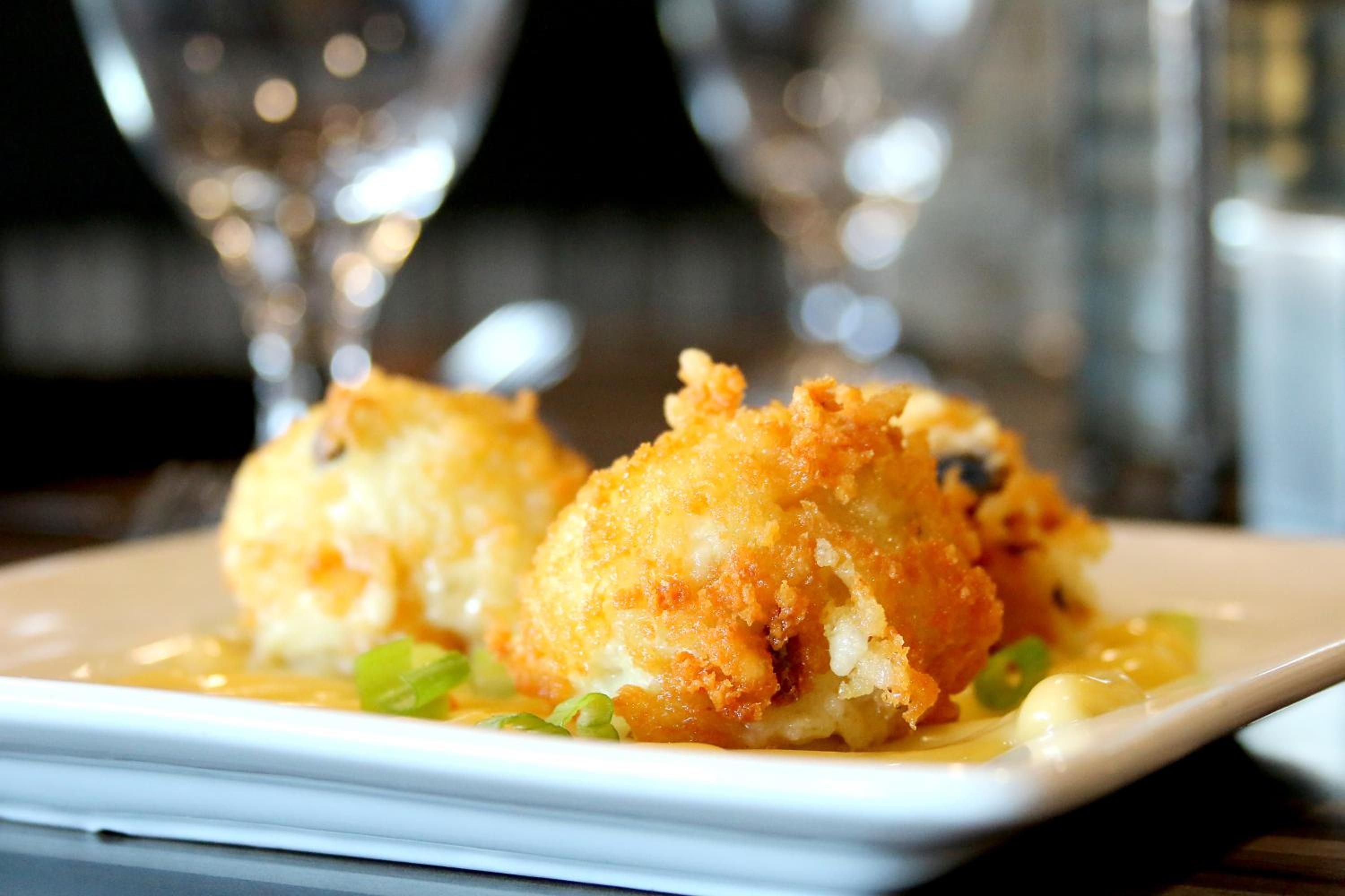 A plate of food with a golden-brown crust, possibly a seafood dish, served on a white plate.