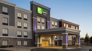 Un edificio de Holiday Inn Express & Suites con fachada moderna, detalles de piedra y una entrada acogedora.