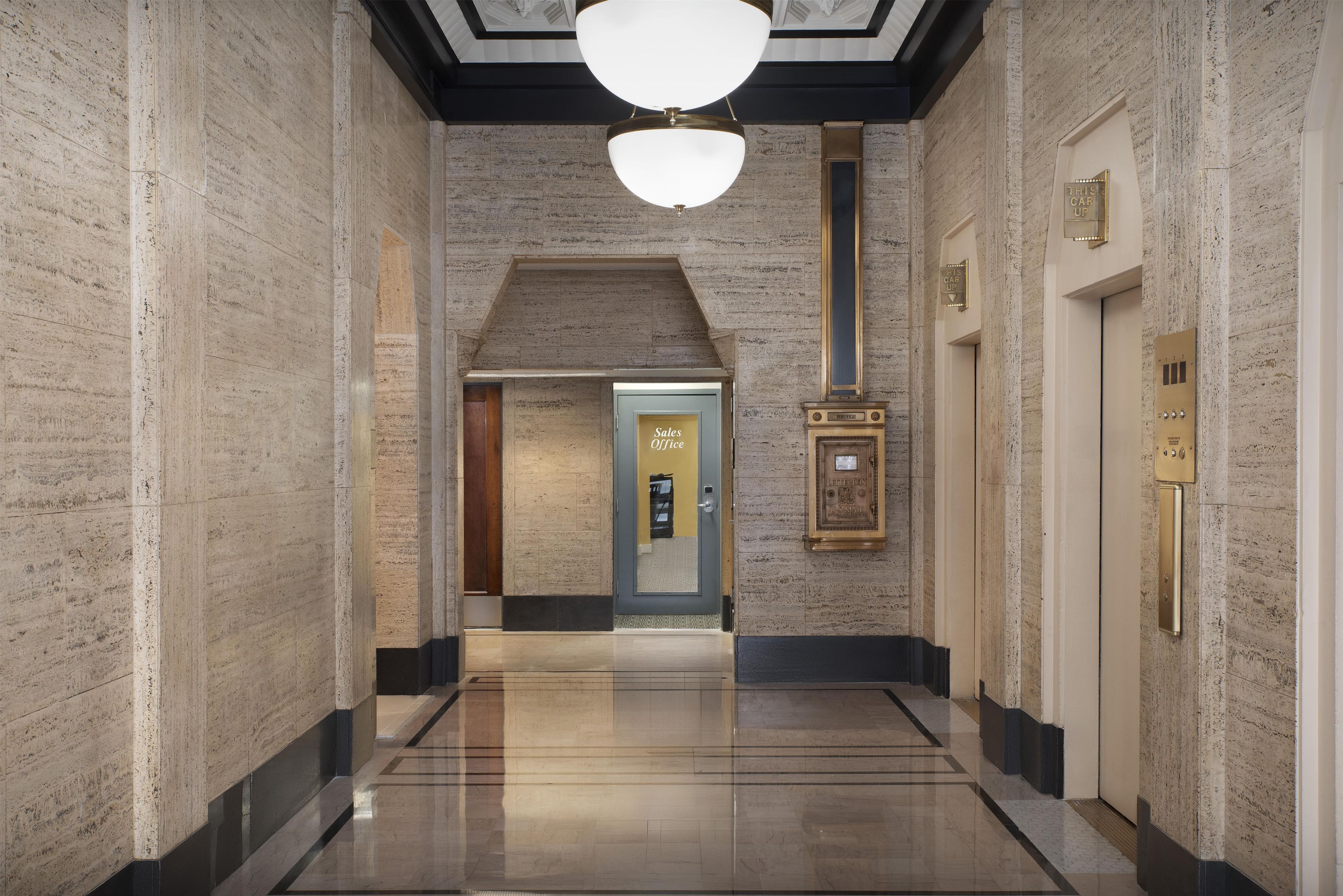 A hallway with a polished floor, a ceiling light, and a door labeled 'Sales Office'.