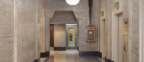 A hallway with a polished floor, a ceiling light, and a door labeled 'Sales Office'.