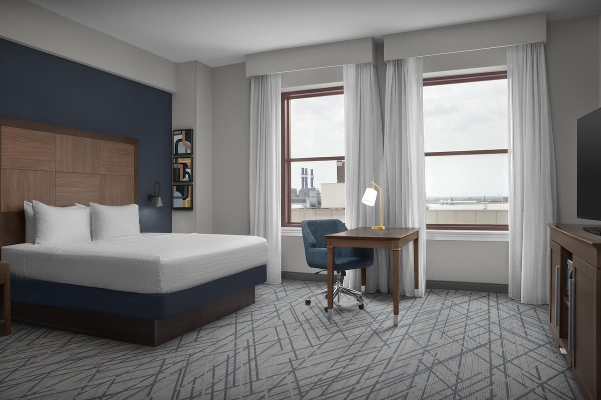 Escritorio, cortinas blackout y tabla de planchar con plancha