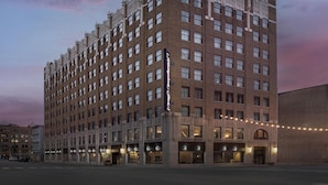 A multi-story hotel with a classic architectural design, featuring a prominent entrance with a marquee sign.