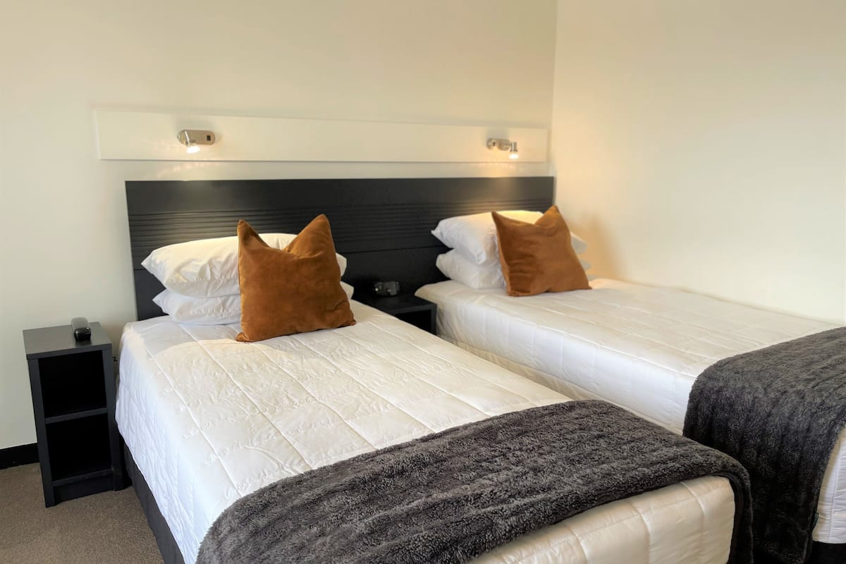 standard twin room | in-room safe, desk, laptop workspace, iron/ironing board