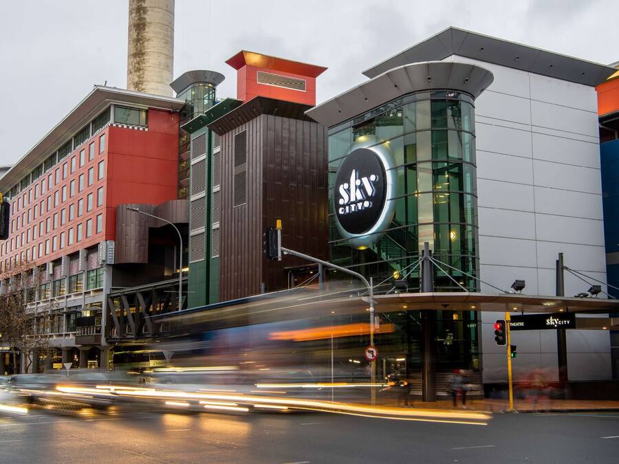 A modern building with a prominent 'SkyCity' sign, featuring a curved glass facade and a mix of red and brown architectural elements.