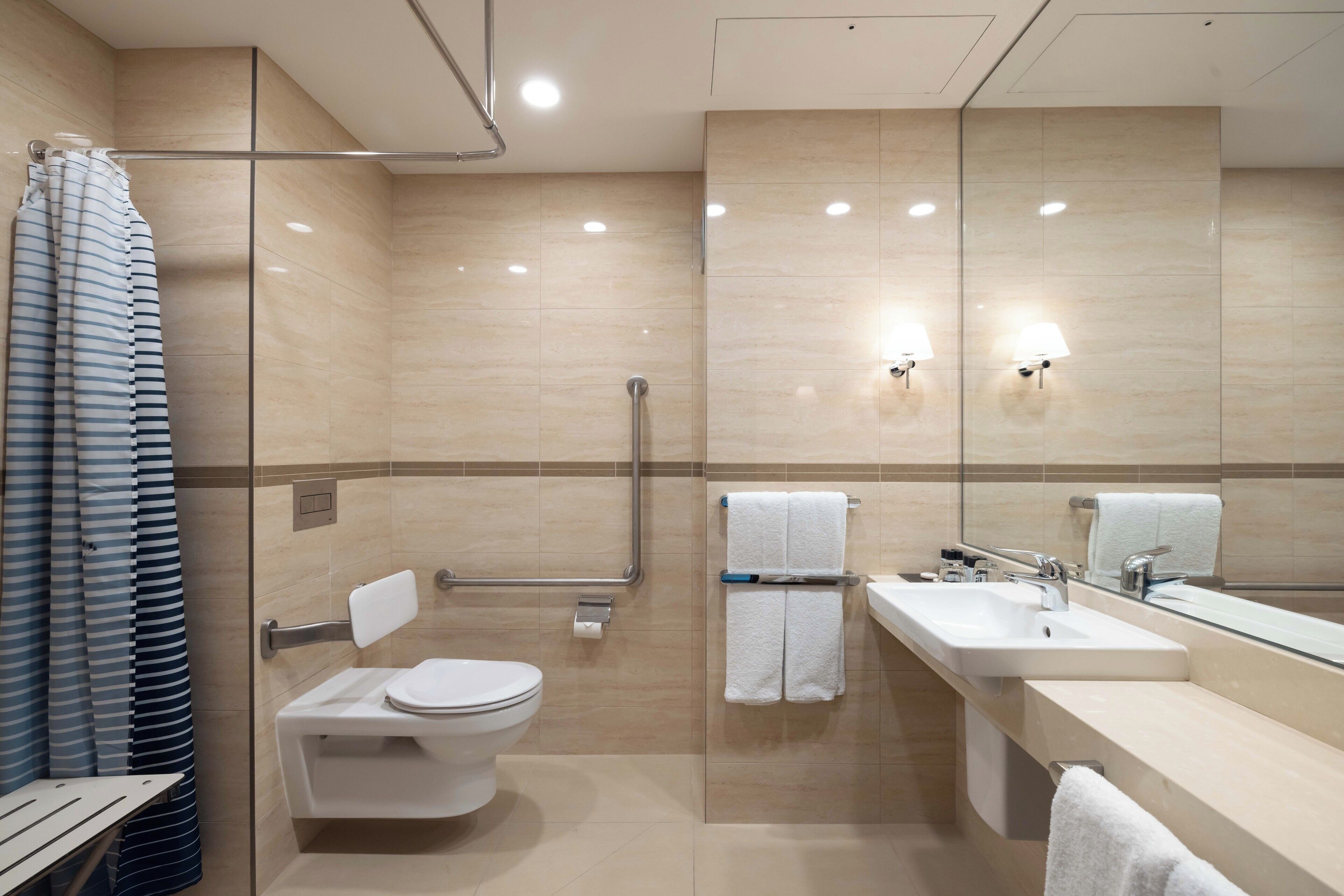 A modern bathroom with a toilet, sink, and shower.