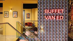 A hotel lobby with a staircase, framed artwork on the walls, and a neon sign reading 'BUFFET VAN ED'. - Leonardo Hotel Amsterdam Leidse Square (Amsterdam)