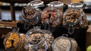 Una exhibición de distintas barras de granola y cereal en frascos de vidrio con cierres metálicos.