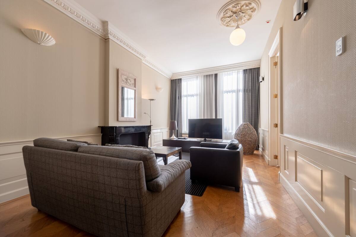 A modern living room with a sofa, a coffee table, and a TV.