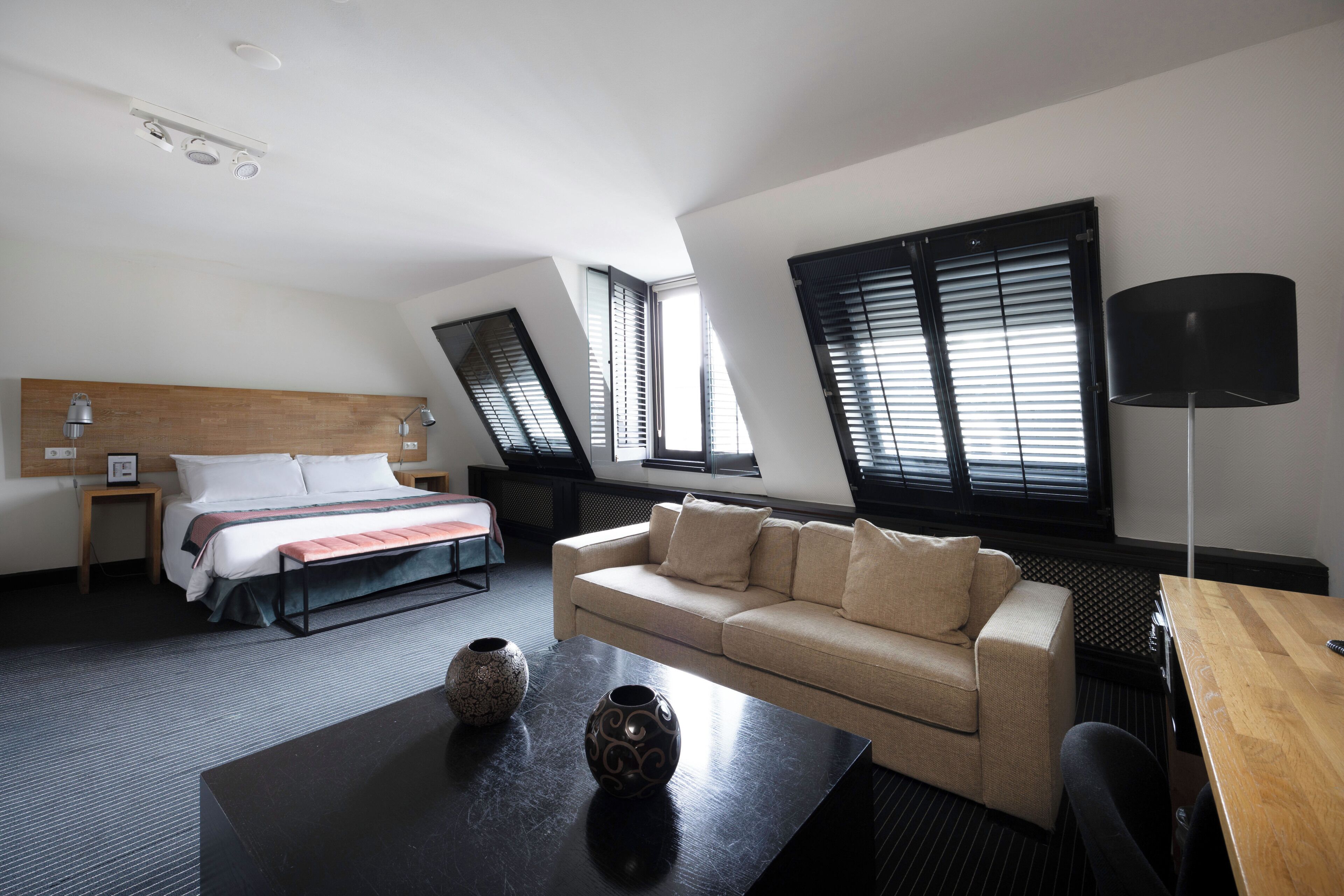 Ein Hotelzimmer mit Bett, Sofa, Tisch und Lampe.