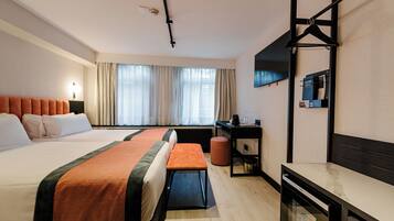 Une chambre d’hôtel avec deux lits, un bureau, une chaise, une petite table, un miroir et un téléviseur.