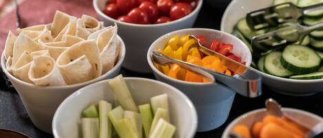 A variety of food items including tortillas, cherry tomatoes, bell peppers, celery, cucumbers, and carrots.