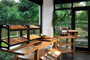 A breakfast buffet with various baked goods and a coffee machine. - Leonardo Boutique Hotel The Lancaster Amsterdam (Amsterdam)