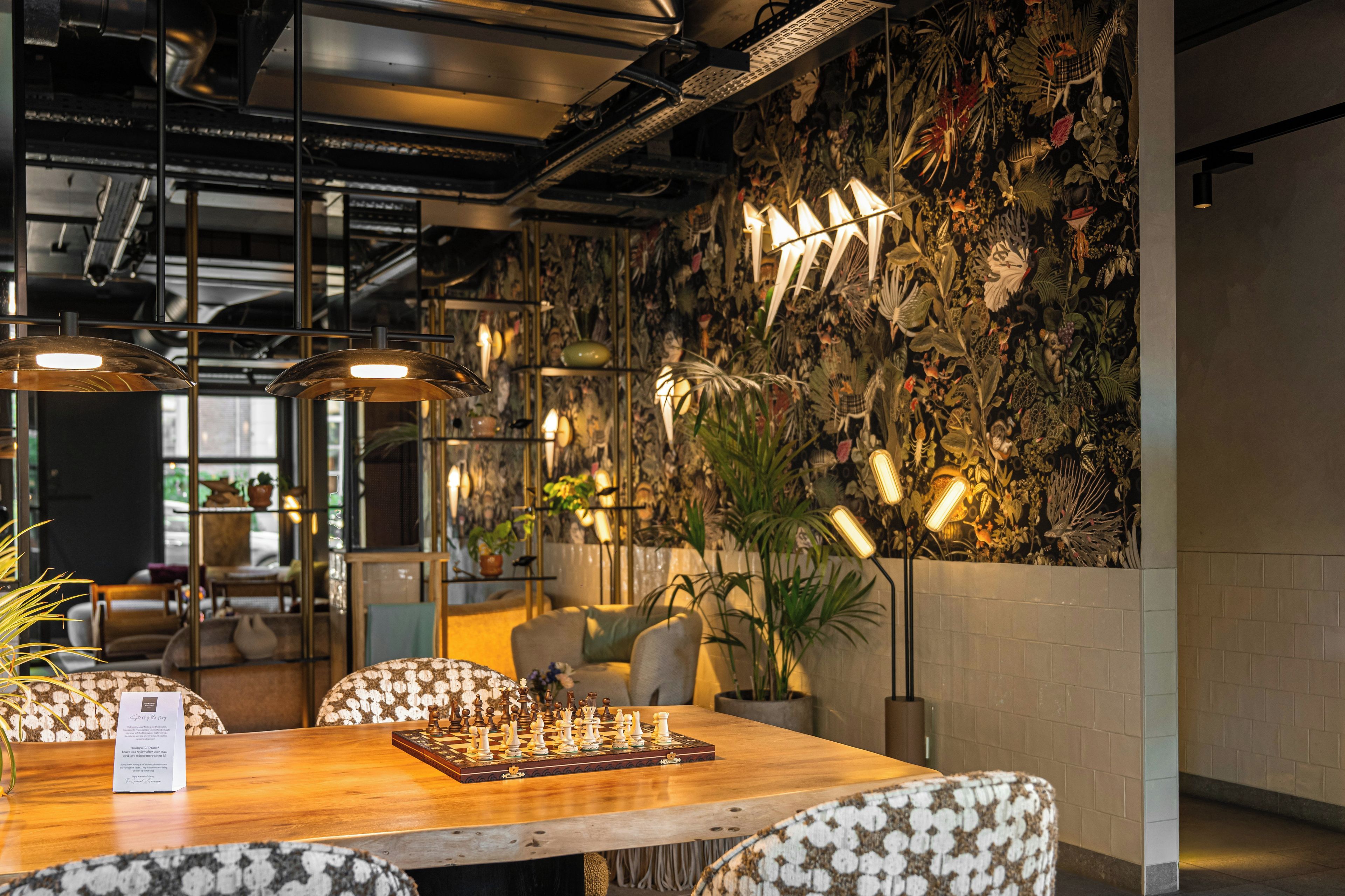 Un ambiente acogedor en el interior, con una mesa de madera, un tablero de ajedrez y sillas estampadas.