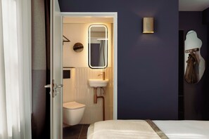 A hotel room with a bed, a bathroom with a toilet, a sink, and a mirror. - Leonardo Boutique Hotel The Lancaster Amsterdam (Amsterdam)