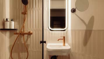 A bathroom with a shower, sink, and mirror.