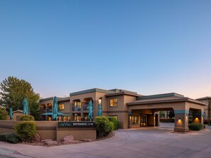 A hotel entrance with a sign, outdoor seating, and a clear sky. - Mountain Modern Sedona, Tapestry Collection by Hilton (Sedona)