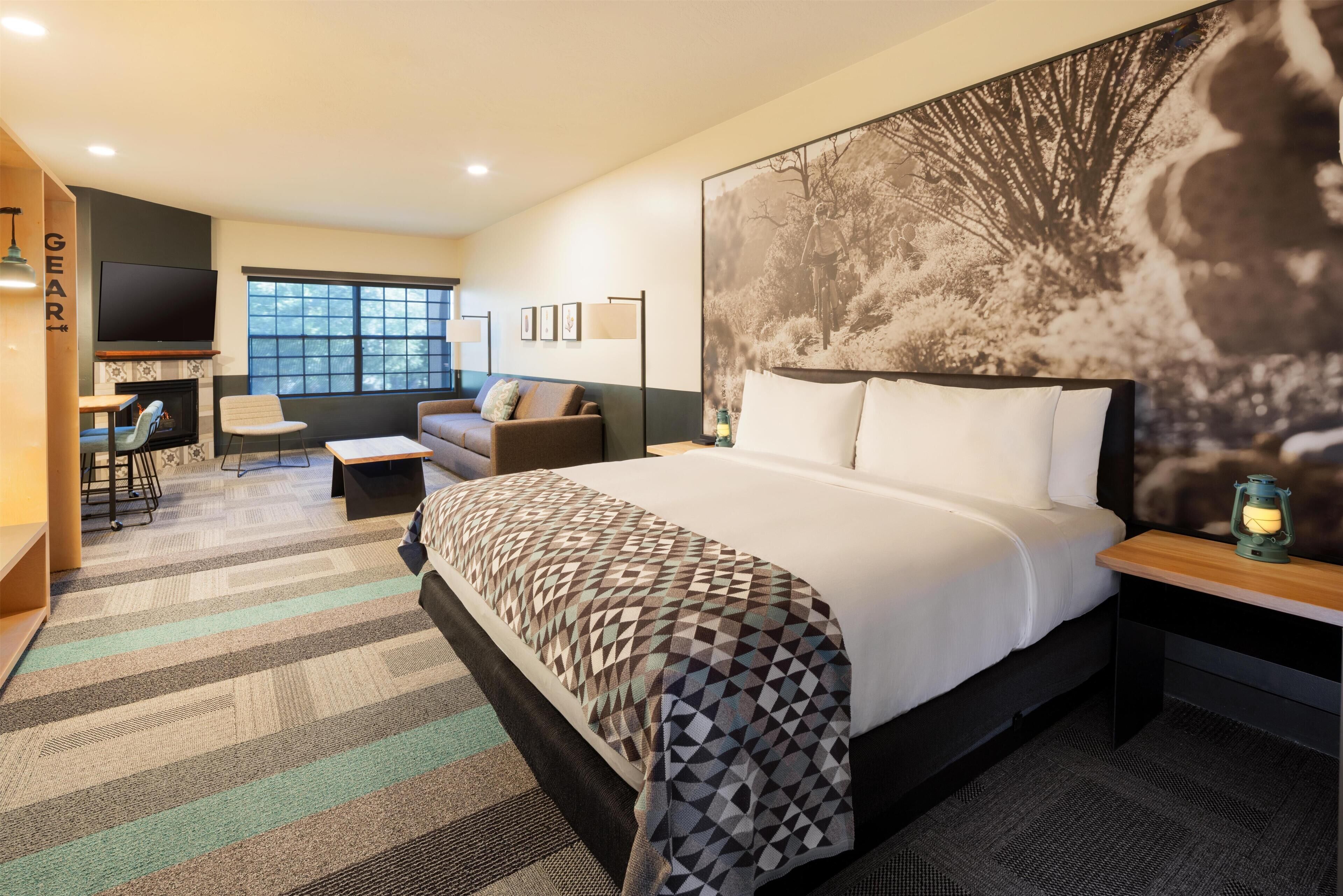 Une chambre d’hôtel avec un grand lit, un canapé, un bureau et une télévision.