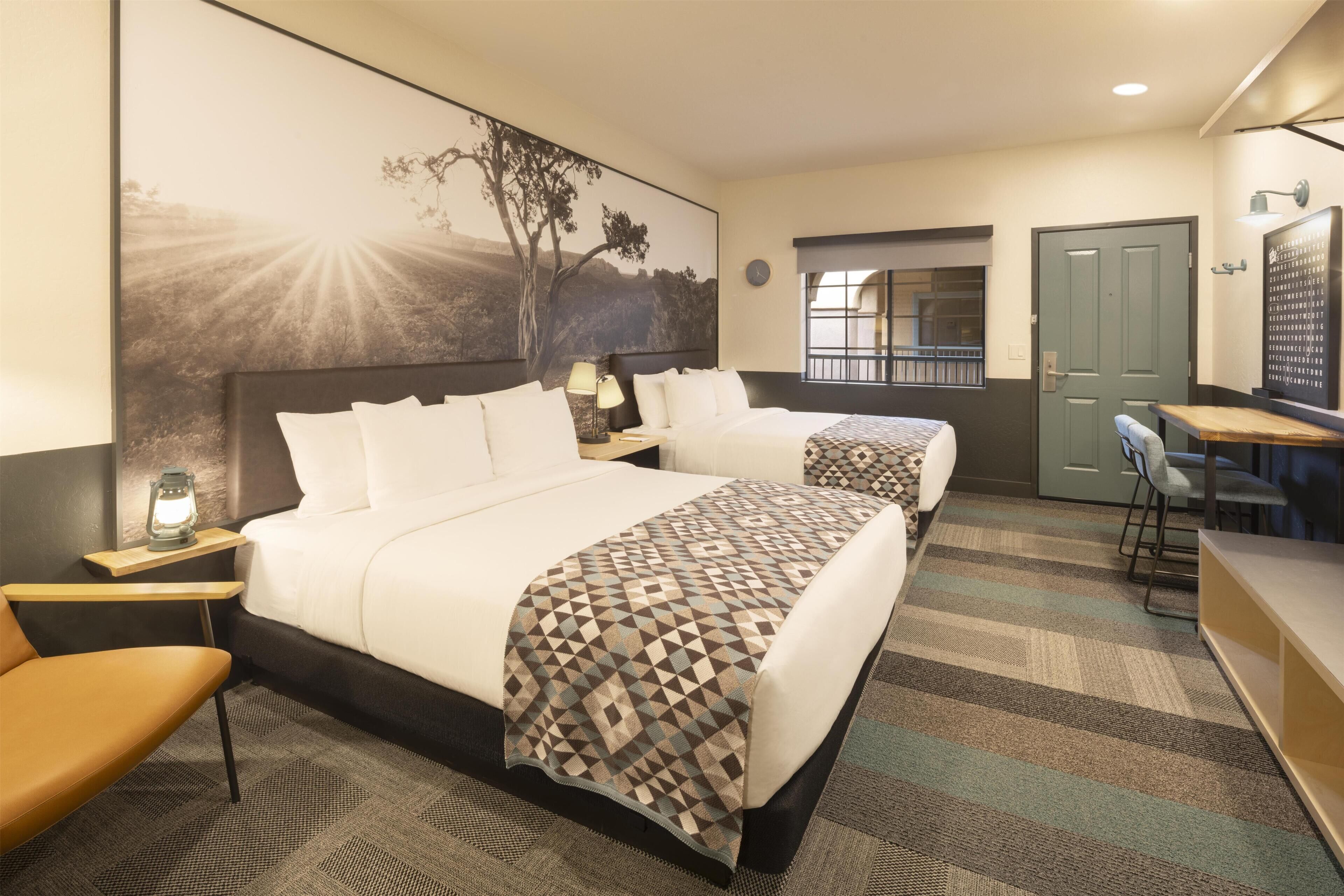 Una habitación de hotel con una cama grande, un escritorio y una silla.