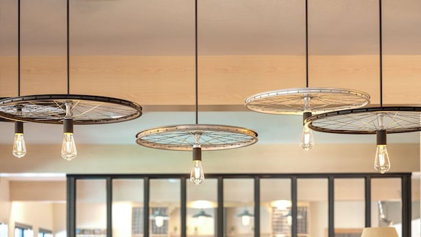 A dining area with a wooden table, four chairs, and hanging pendant lights. - Mountain Modern Sedona, Tapestry Collection by Hilton (Sedona)