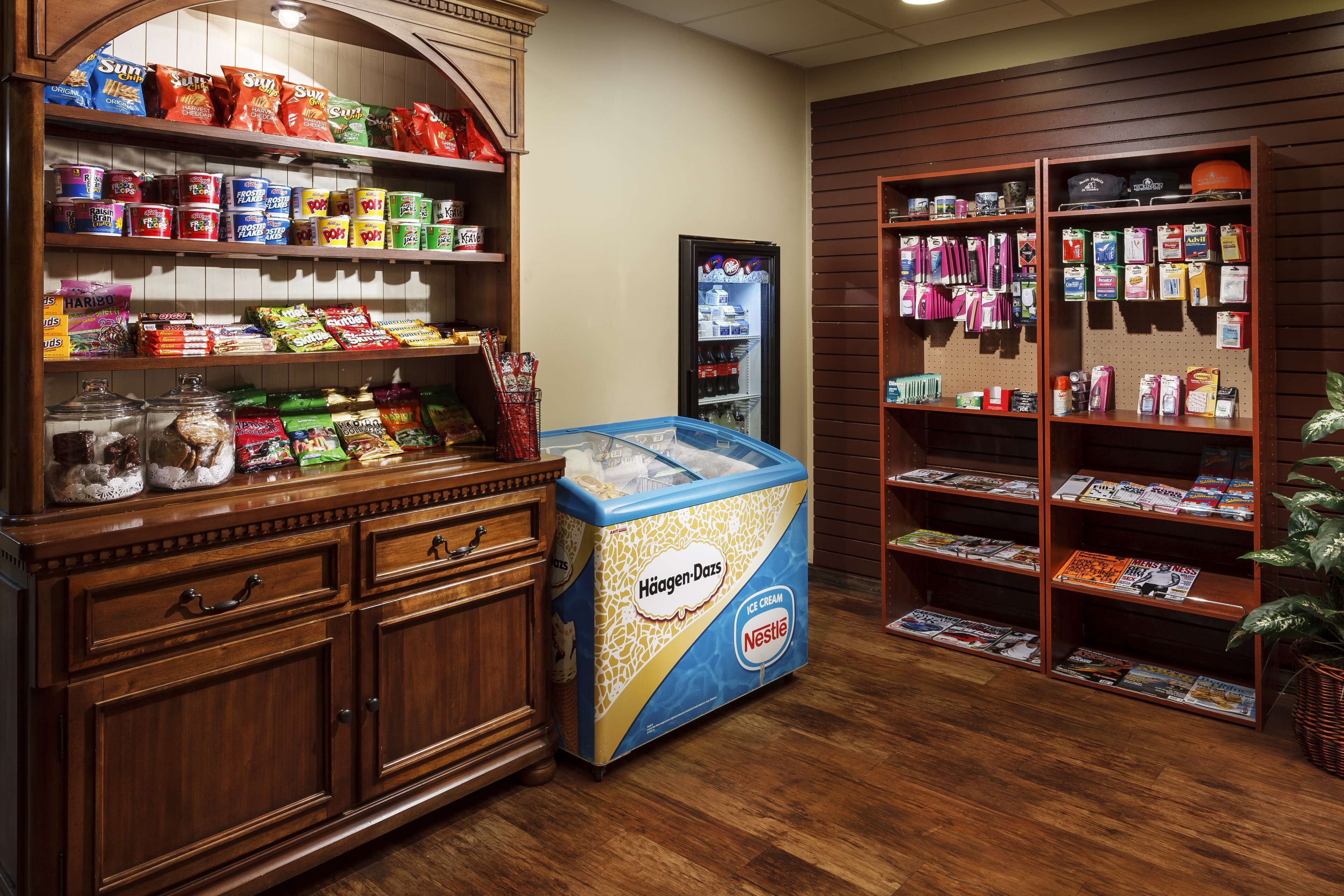 Zona de exhibición de aperitivos y helados, con varios productos envaselados y un refrigerador grande de Häagen-Dazs.