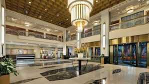 A spacious lobby with a high ceiling, a central chandelier, and a reception desk. - NEW YORKER BY LOTTE HOTELS (New York)