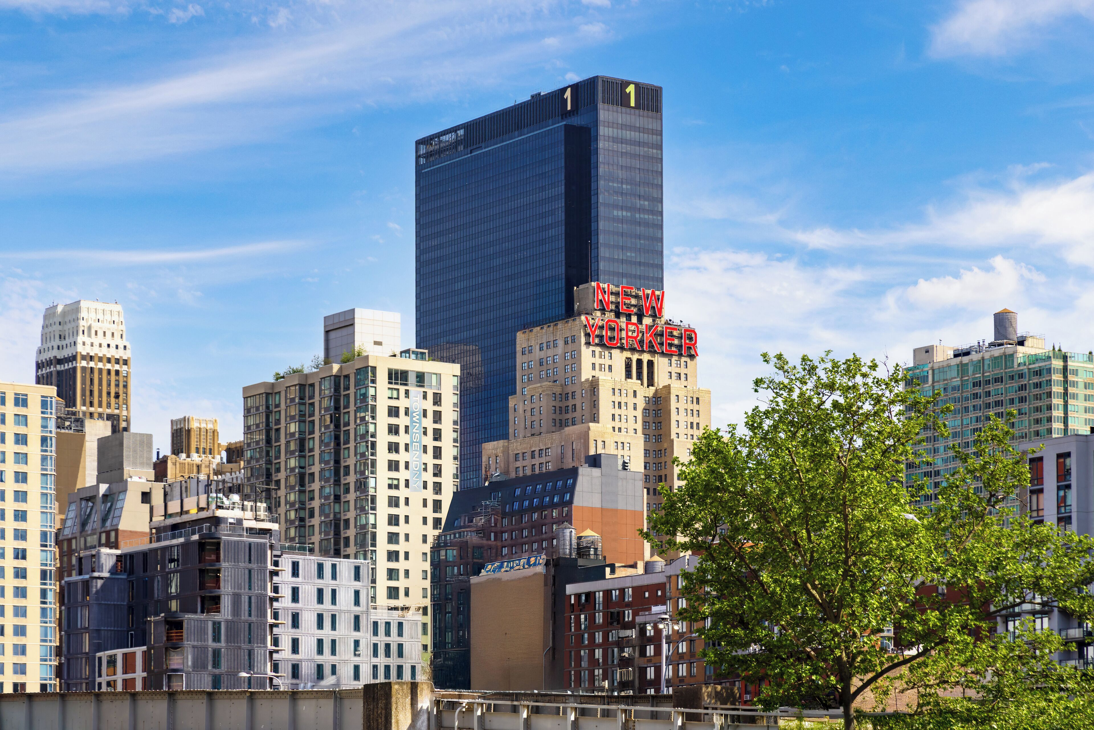 A cityscape with a prominent skyscraper labeled 'NEW YORKER' and various other buildings.