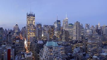 Un paisaje urbano con diversos edificios altos, incluyendo un rascacielos destacado con un pináculo.