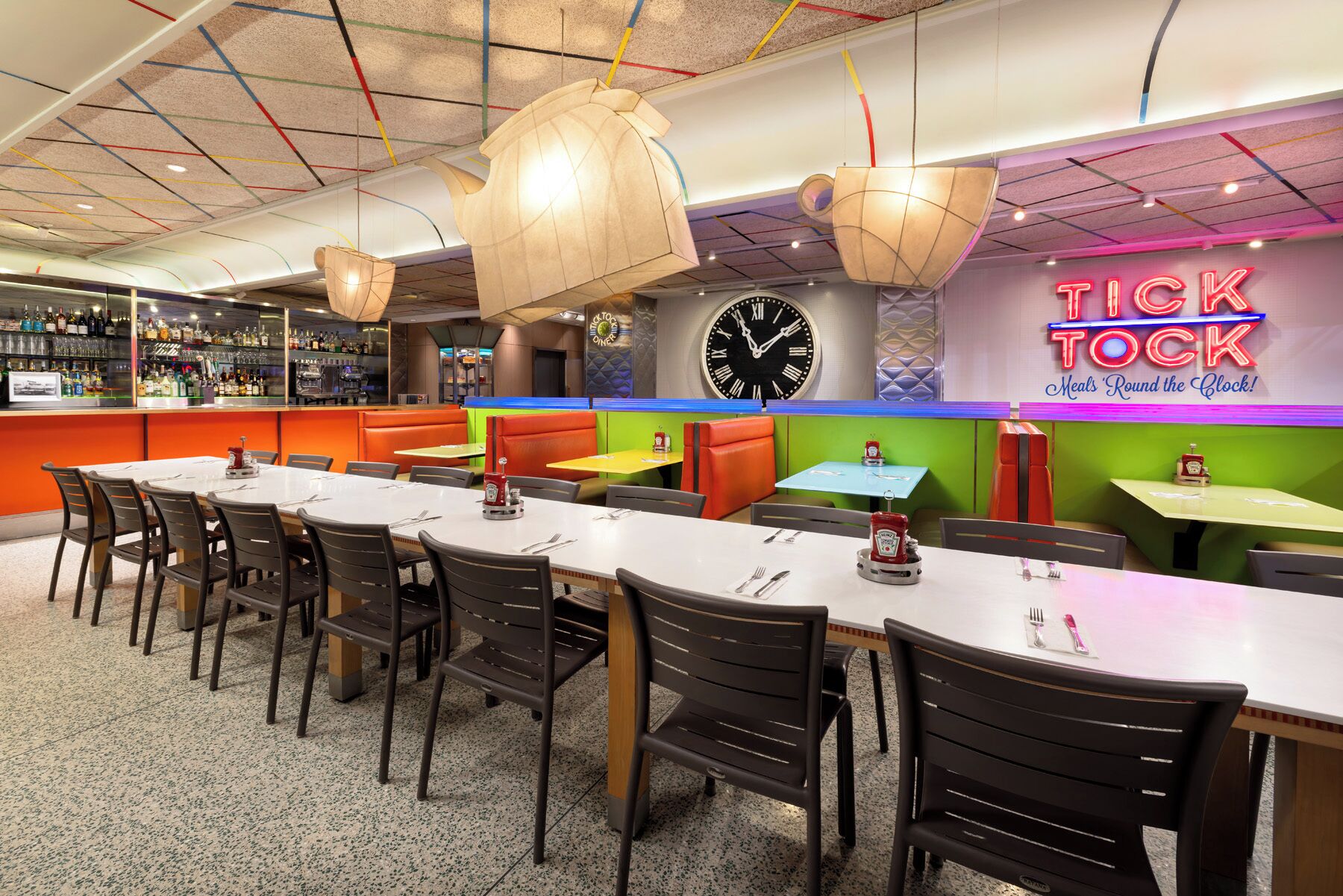 A restaurant with multiple seating areas, including booths and tables, and a bar with a variety of bottles.