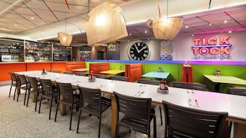 Un restaurante con varias zonas de estar, incluyendo cabinas y mesas, y una barra con una variedad de botellas.