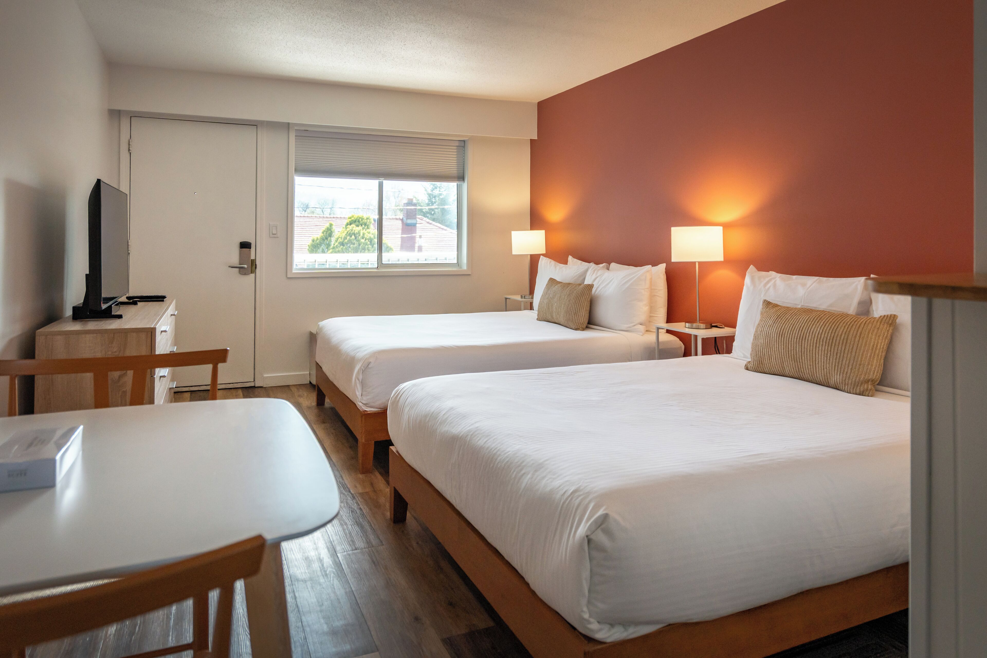 Una habitación de hotel con dos camas, un escritorio y una televisión.