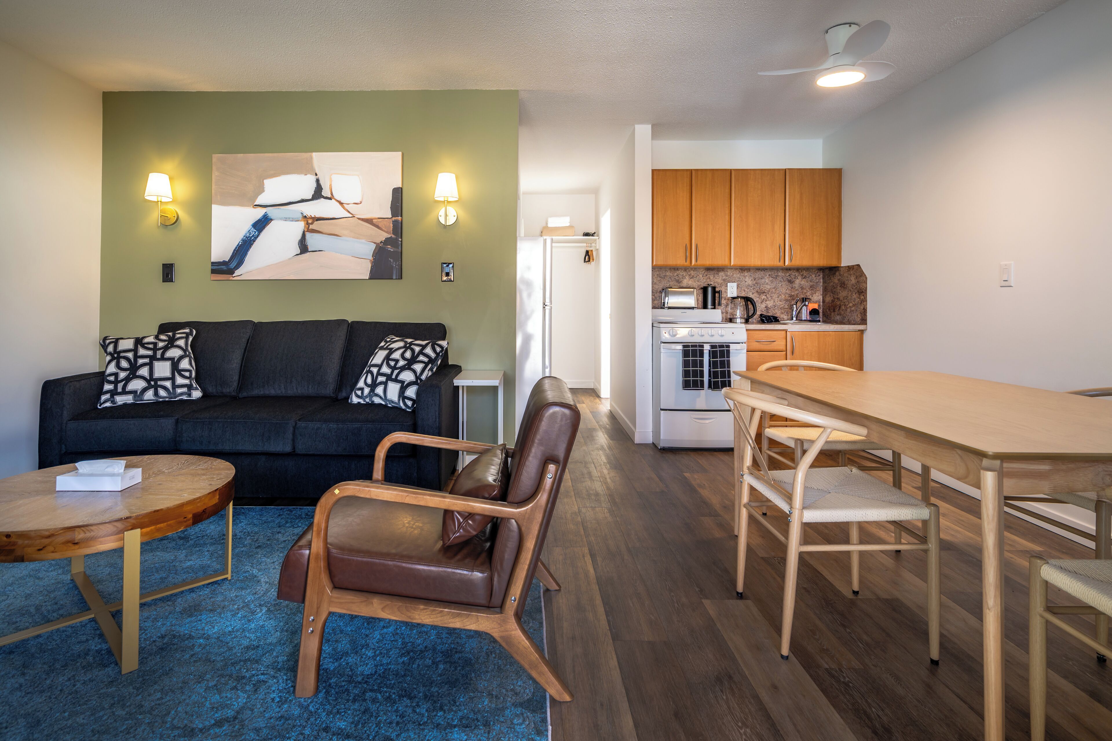 A compact living space with a sofa, a dining table, and a kitchenette.