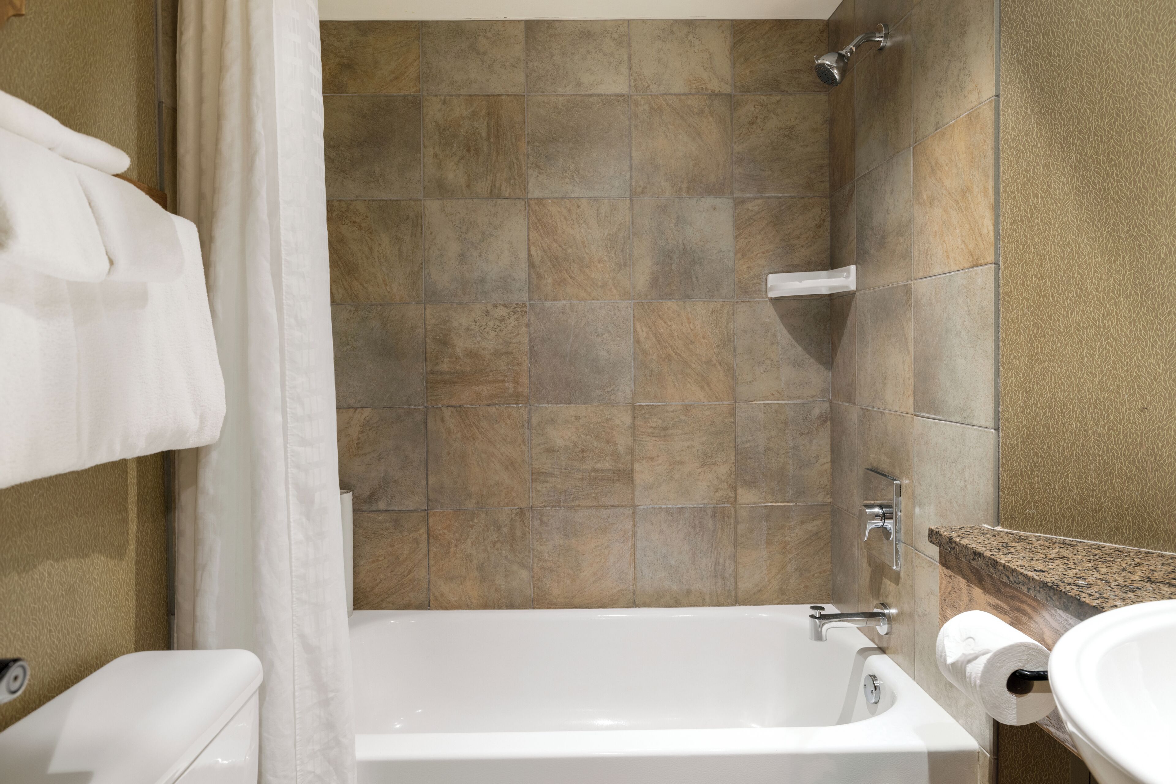 A bathroom with a bathtub, a shower, and a sink.
