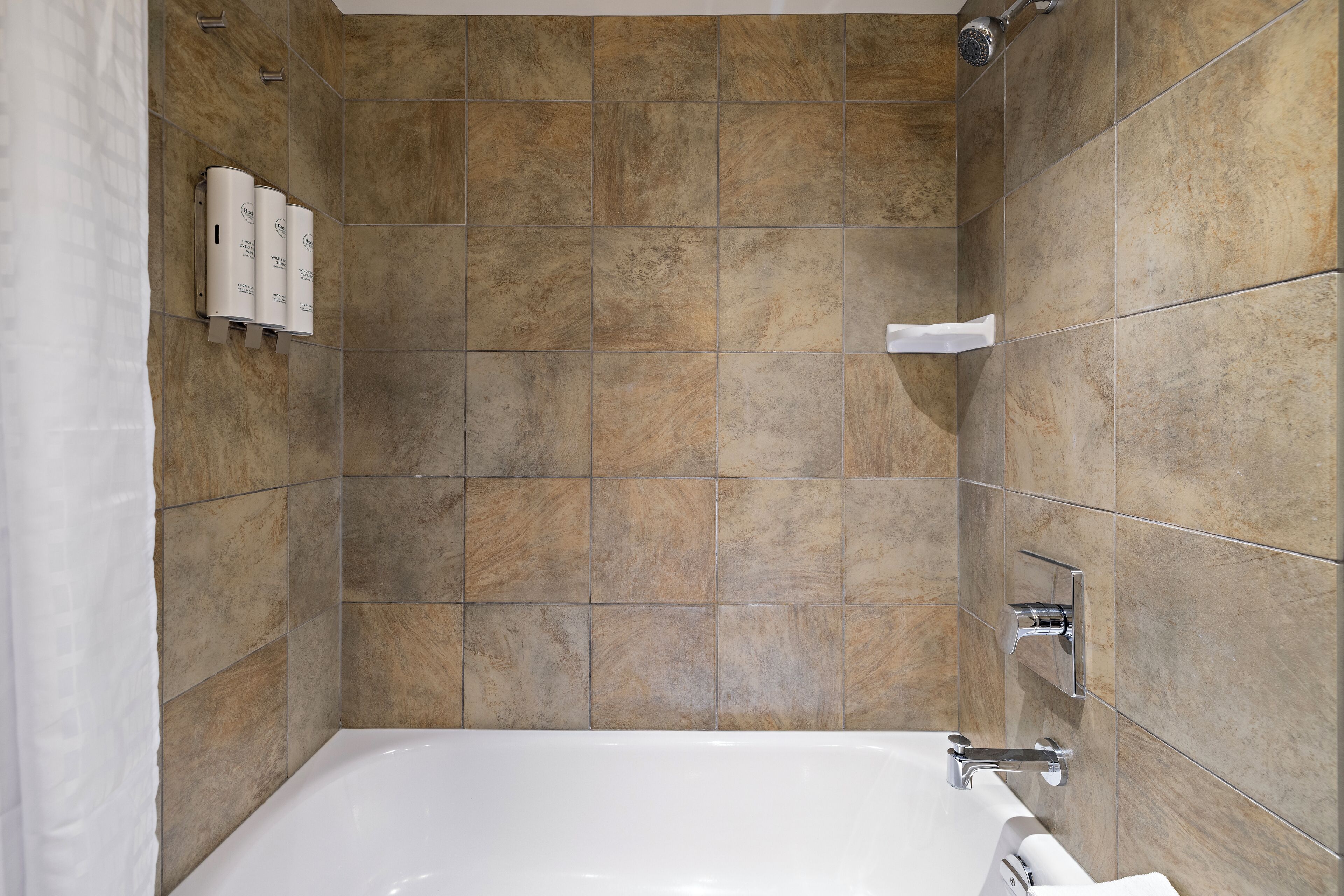 Une salle de bain moderne équipée d’une baignoire, d’une douche et d’un sèche-mains.