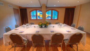 Une salle de conférence équipée d’une table ronde, de six chaises et de deux compositions florales.
