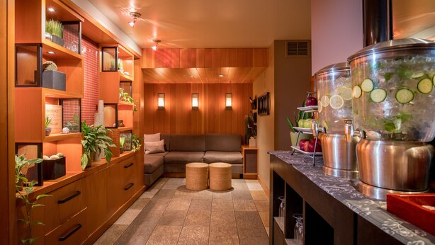 A modern kitchen with wooden cabinets, a built-in oven, and a large island with a sink. - Banff Caribou Lodge and Spa (Banff)