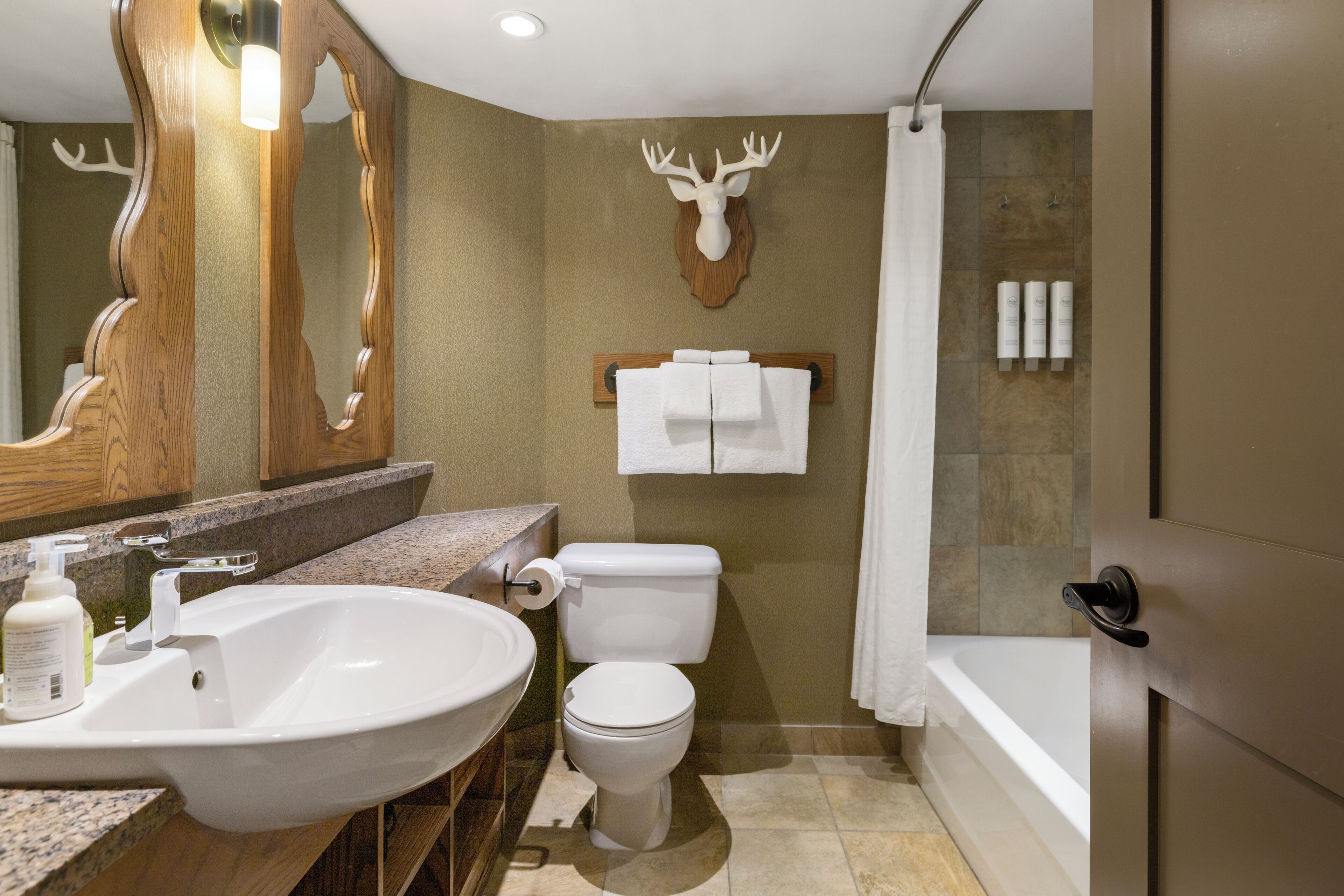 A modern bathroom with a large sink, toilet, and shower.