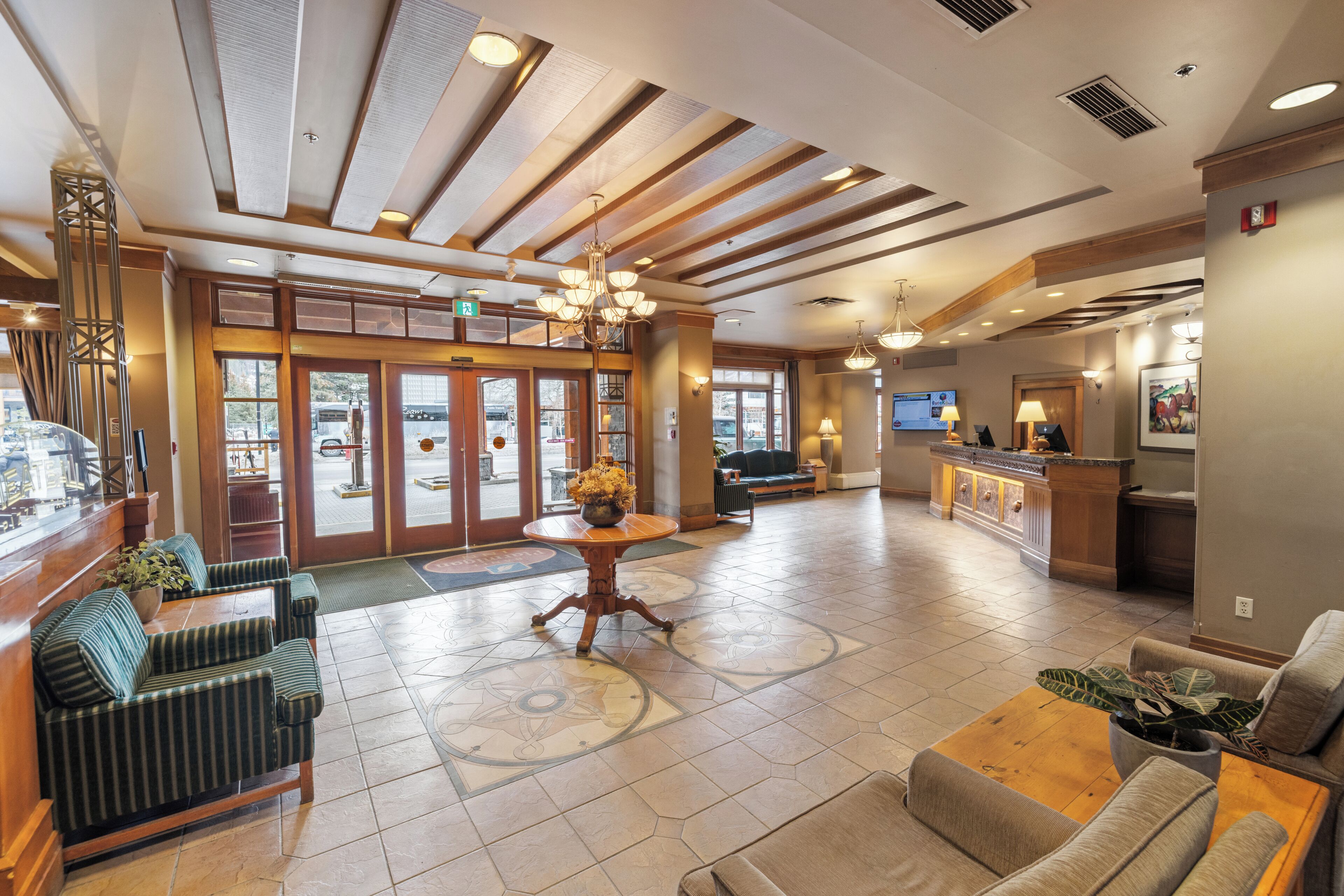 A spacious lobby with a reception desk, seating area, and a large window overlooking the street.