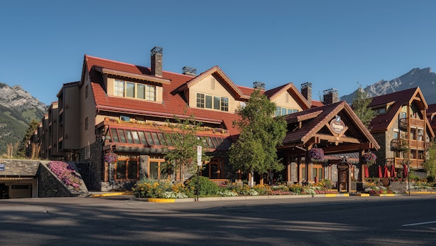 A multi-story hotel with a traditional architectural style, featuring a prominent entrance with a wooden facade and a balcony with flower boxes. - Banff Ptarmigan Inn (Banff)
