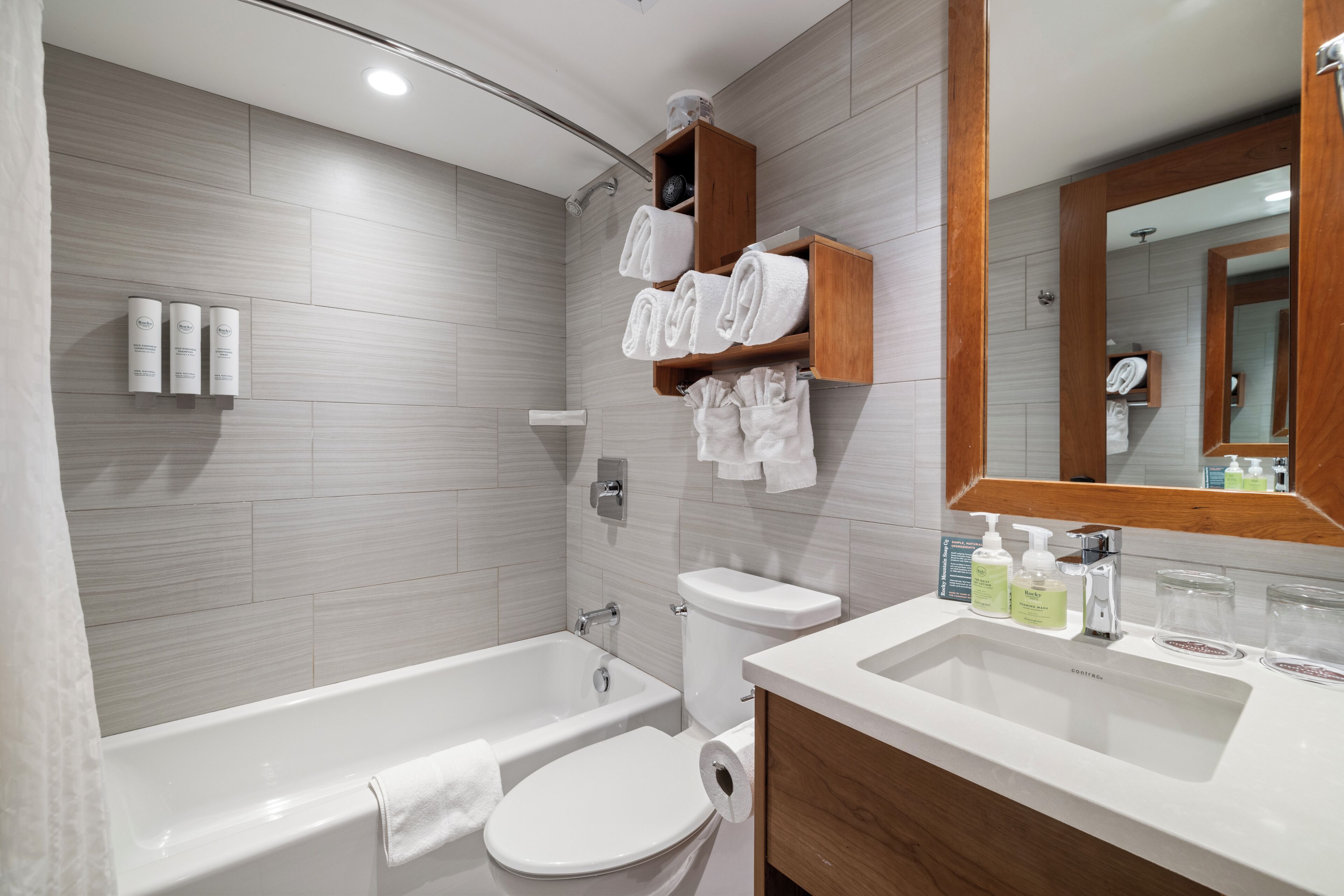A modern bathroom with a bathtub, toilet, and vanity.