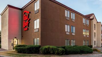 A multi-story hotel with a red neon sign reading "Real Roof Inn".