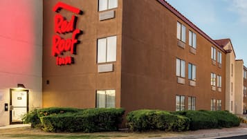Un hotel con un cartello rosso che riporta la scritta "Red Roof Inn" e un design architettonico moderno.