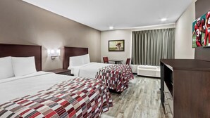 Une chambre d’hôtel avec deux lits, un bureau, une chaise, une télévision et un tableau au mur.