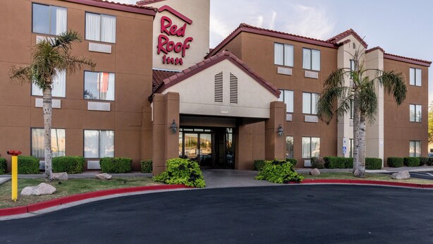 Un bâtiment de la chaîne Red Roof Inn, avec une façade marron, de nombreuses fenêtres et un parking situé à l’avant.