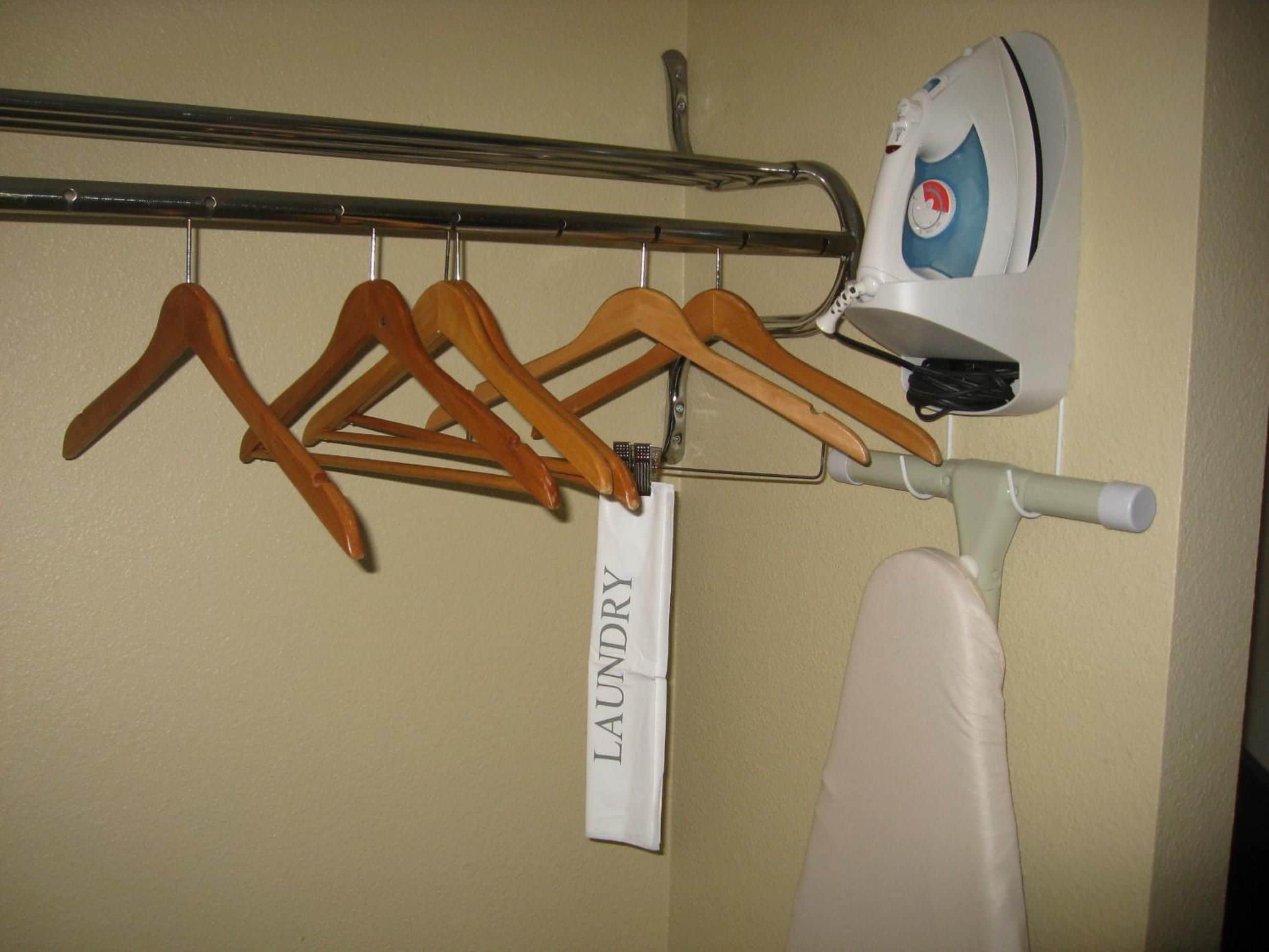 A laundry area with wooden hangers and a white ironing board.