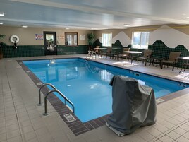 Una piscina techada, sillones reclinables de piscina