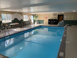 Una piscina techada, sillones reclinables de piscina